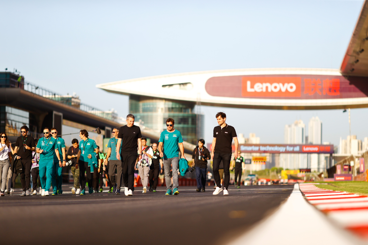 Fernando Alonso camina junto a su equipo por el circuito de Shangai.