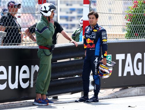 Checo Pérez de pie junto a un comisario tras el accidente en Mónaco