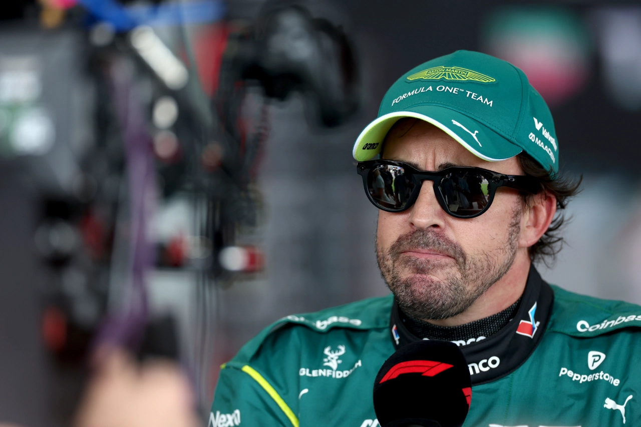 Fernando Alonso con gesto de preocupación hablando en el paddock