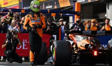 Lando Norris caminando al lado de su McLaren