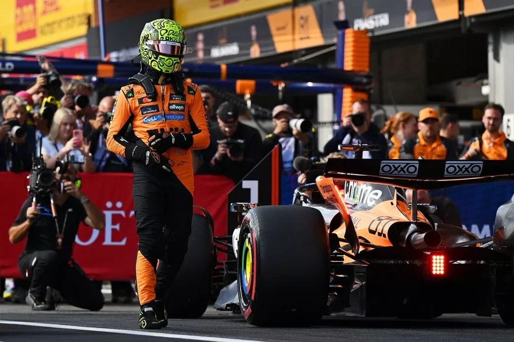 Lando Norris caminando al lado de su McLaren